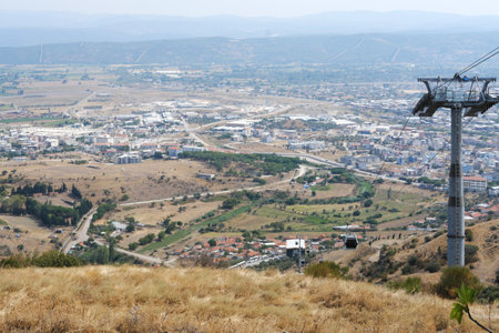 A panoramic aerial view of Bergama, featuring the cable car system with a backdrop of urban and rural landscapesの写真素材