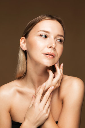 A young Caucasian woman with clear, radiant skin, showing the positive effects of proper sleep on skin health. Bare shoulders and serene expression highlight natural beauty.の写真素材