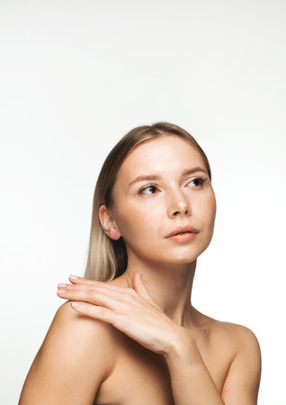 Young Caucasian woman with bare shoulders and blonde hair showing her clear and healthy skin.の写真素材