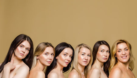 Diverse group of women of different ages with bare shoulders against a beige background, perfect for advertising banners.の写真素材