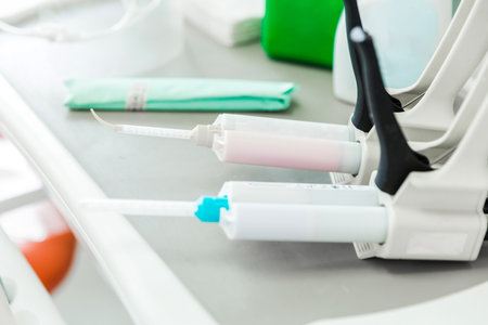 Close-up of dental equipment and supplies neatly arranged on a tray in a modern dental clinic. Various instruments and sterilization items are visible.の写真素材