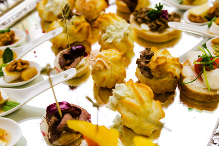 An elegant display of various savory pastries and bites presented on a decorative silver tray.の写真素材