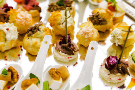 A collection of gourmet appetizers displayed elegantly on a reflective surface, showing culinary artistry.の写真素材