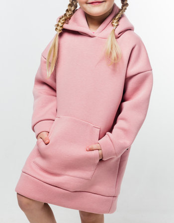 A young girl with braided hair wearing a cozy pink hoodie with a front pocket. Vertical photoの写真素材