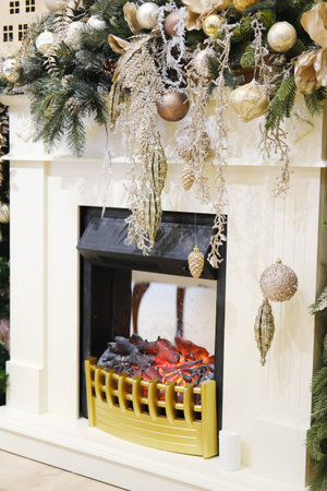Beautifully decorated fireplace with a glowing fire, surrounded by festive ornaments and greenery, enhancing the cozy ambiance for holiday celebrationsの写真素材