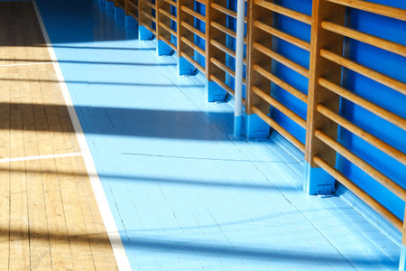 Interior of a school gym featuring a polished wooden floor and blue walls, creating an inviting atmosphere for sports activities and physical education classesの写真素材