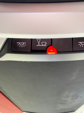 Control panel in a bus showing illuminated warning lights for seatbelt and refreshment service...