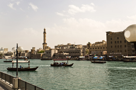 View of Dubai Creek with traditional boat taxi activity. The creek is dividing the city into two main sections: Deira and Bur Dubaiのeditorial素材