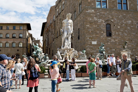 Tourists in front of Fountain of Neptune located in Piazza Della Signoria in Florence, Italy.のeditorial素材