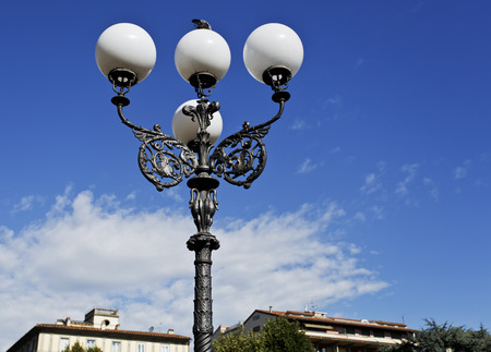 Lamppost with a beautiful iron pole and four globes on a public park in Florence, Italyの写真素材
