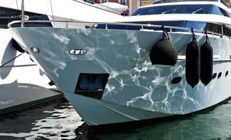 Water reflections on the bow of a super yacht moored at the port of St Tropez, France
