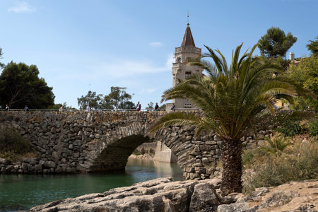 The stone bridge crossing the inlet near the Palace of Conde de Castro Guimaraes, also known as the Tower of Saint Sebastien, in Cascais, Portugalの写真素材