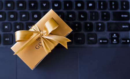 Illustrative editorial photo of a wrapped up stylish box of chocolates on a laptop keyboardの写真素材