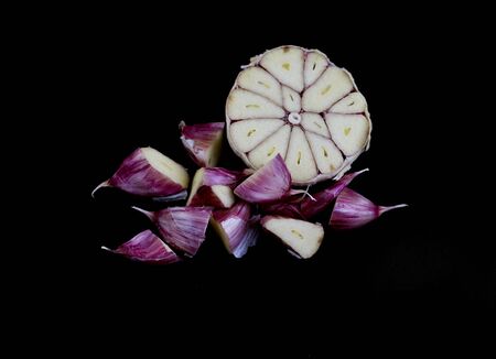 Cloves of garlic, Allium sativum, cut on the cross section, on black backgroundの写真素材