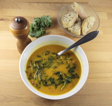 Pumpkin, red lentils and kale delicious soup in a white bowlの写真素材