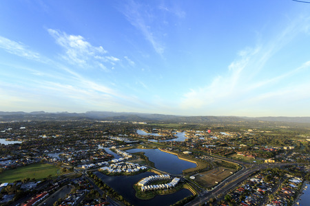 View of a hot air balloon flying at sunrise over the canals at the Gold Coast, Queensland Australiaの写真素材