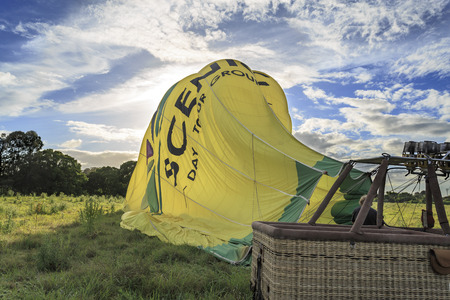 Hot air balloon being deflated by a ground crew member after a soft landing in the Gold Coast, Queensland, Australiaのeditorial素材