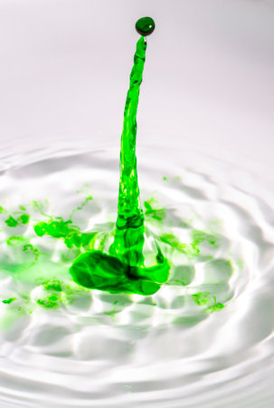 Clear water drop on a green tinted water.の写真素材