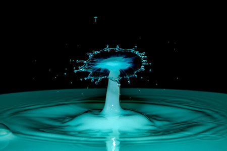 Blue water drop collision over a black backgroundの写真素材
