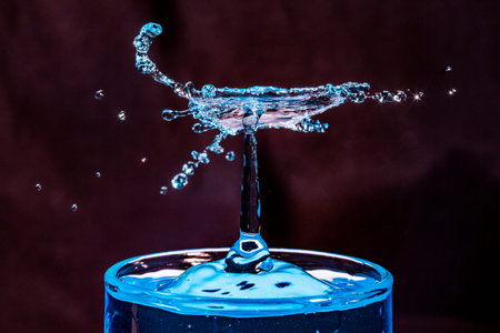 Macro shot of a blue water drop collision in a glass of water.の写真素材