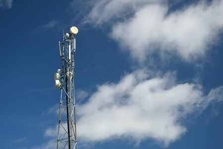 Telecommunication tower with blue sky and clouds in the backgroundの写真素材