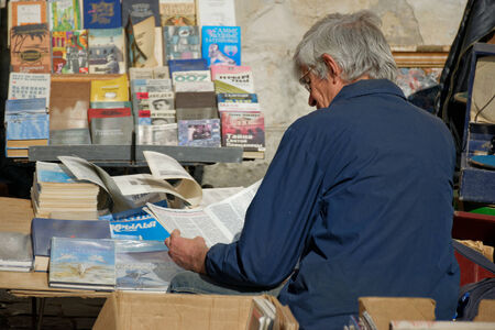 LVIV, UKRAINE - OCTOBER 4, 2014: Book flea market near the monument of Ivan Fyodorov. Man selling his books and looking at second hand book on 4 October 2014, Lviv, Ukraine.のeditorial素材