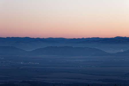 Landscape with violet silhouettes of remote mountain ranges in the eveningの写真素材