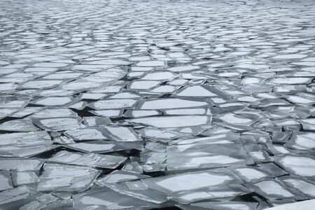 Floating snowy cracked ice flow in the Baltic sea forming a texture with patternの写真素材