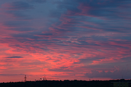 Violet patterned sky with waves of pink clouds after the sunsetの写真素材