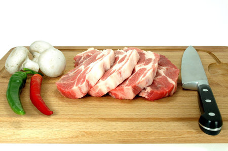 Pork chops and vegetables  on cutting board.