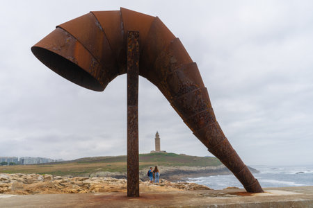 Sculpture of the Caracola and in the background the Tower of Hercules in the city of A Coruna in Galicia, Spainのeditorial素材