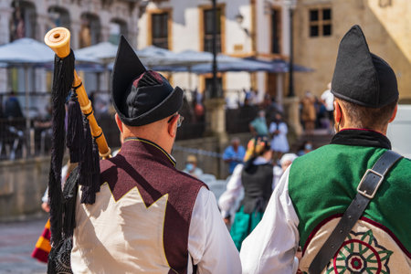 Two men dressed in Asturian costume playing the drum and bagpipes in a square in Oviedo, Uvieu, in Asturias.の写真素材