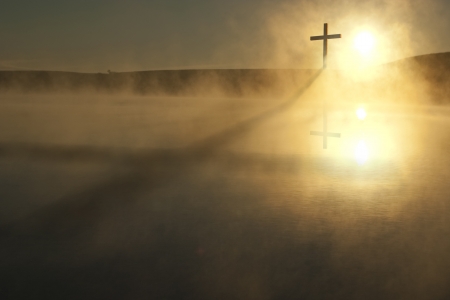 This Sunrise Cross on a misty lake casts a lengthy shadow and reflection on this calm Easter Morning Illustration This Sunrise Cross on a misty lake casts a lengthy shadow and reflection on this calm Easter Morning Illustration