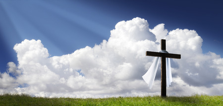 This dramatic Easter Morning Sunrise panorama with blue sky, sunbeams, and large cross on a grass covered hill makes a great banner cover for print or web This dramatic Easter Morning Sunrise panorama with blue sky, sunbeams, and large cross on a grass covered hill makes a great banner cover for print or web