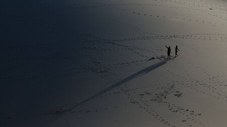 Silohuettes of a couple taking a selfie in the middle of a desertのeditorial素材