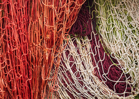 Close-up of fishing nets stacked in the harbor, paying particular attention to the colors, textures, materials, details, knots, etc.のeditorial素材