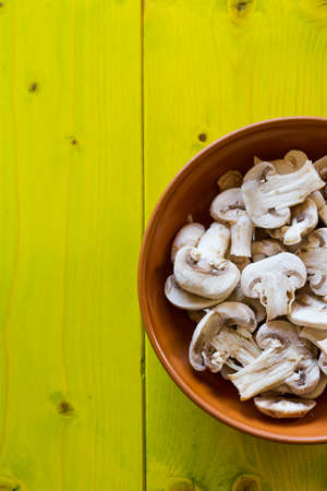 Whole Champignons in a Bowl on Wooden Boards, closeupの写真素材