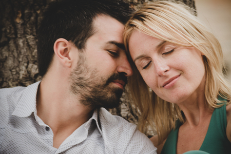 Young beautiful couple flirting sitting in a gardenの写真素材