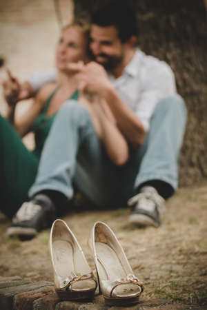 Young beautiful couple flirting sitting in a gardenの写真素材