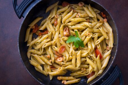 Pasta in the pan with cherry tomatoesの写真素材
