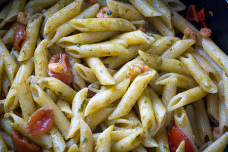 Pasta in the pan with cherry tomatoesの写真素材