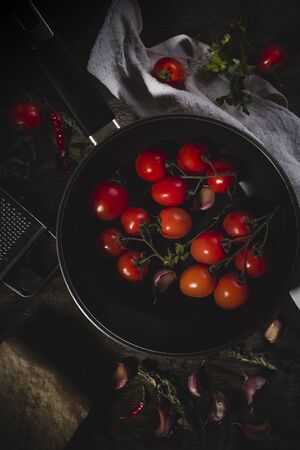 Cherry tomatoes freshly picked and thrown into the pan with various spicesの写真素材