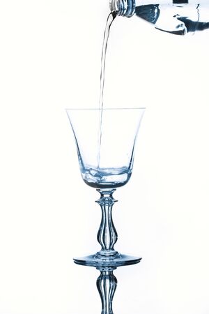 Water poured into a glass from a plastic bottleの写真素材