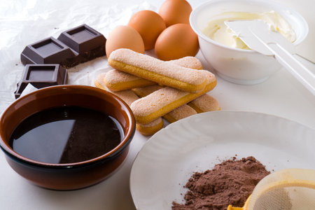 Ingredients for cooking tiramisu cake. Chocolate, butter, eggs, sugar, cocoa powder.の写真素材