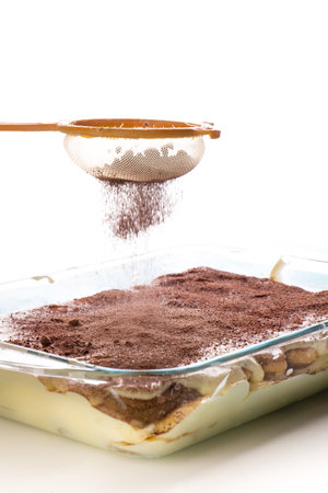 Tiramisu cake in a glass baking dish on a white backgroundの写真素材