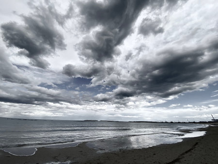 Dark and white clouds gathering over the Adriatic Sea in Pescara, Italy, creating a dramatic and moody atmosphereの写真素材
