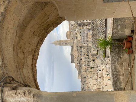 Stunning view of Matera's Sassi di Matera, a UNESCO World Heritage site, seen through an ancient archway, showcasing the city's unique architecture and timeless beautyの写真素材