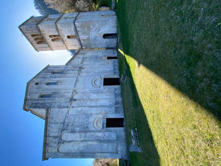 Majestic San Liberatore a Maiella Abbey, a medieval Benedictine monastery in Abruzzo, Italy, casts long shadows on the grassy field on a sunny dayの写真素材