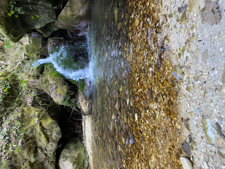 Clear water flowing from a small waterfall on rocks and pebbles in a stream in Serramonacesca, Abruzzo, Italy, creating a peaceful natural sceneの写真素材
