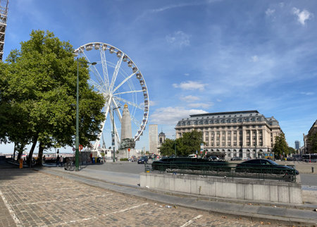Brussels skyline featuring Ferris wheel, landmark, and Hotel Le Plaza at Place Poelaert, basking in bright summer sunlightの写真素材